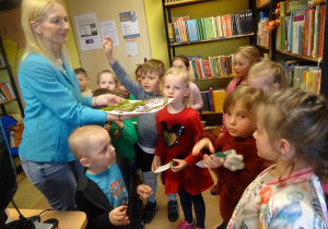 Dzieci stoją wokół pani Małgorzaty Hofamnn, trzymają w ręku zakładki do książek.